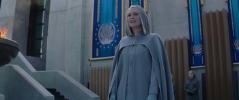 Movie still from “The Hunger Games: Mockingjay - Part 2” (2015), directed by Francis Lawrence – A woman standing in front of a wall with a flag behind it; Medium shot, Low angle