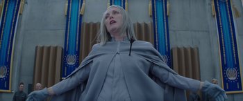 Movie still from “The Hunger Games: Mockingjay - Part 2” (2015), directed by Francis Lawrence – A woman with long blonde hair wearing a gray outfit; Medium shot, Low angle