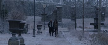Movie still from “The Hunger Games: Mockingjay - Part 2” (2015), directed by Francis Lawrence – Two women are standing on a path in the snow; Wide shot, High angle