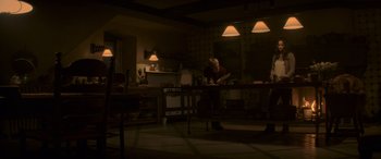 Movie still from “The Hunger Games: Mockingjay - Part 2” (2015), directed by Francis Lawrence – A man is cooking in a kitchen at night; Wide shot, Low angle