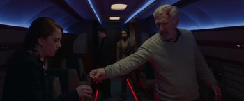 Movie still from “The Hunt” (2020), directed by Craig Zobel – A man holding a pair of red lasers while another man watches; Medium shot, Over the shoulder angle