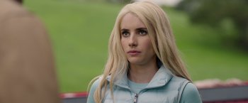 Movie still from “The Hunt” (2020), directed by Craig Zobel – A woman with long blonde hair wearing a light blue jacket; Close Up shot, Over the shoulder angle