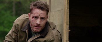 Movie still from “The Hunt” (2020), directed by Craig Zobel – A person wearing a jacket with blood all over his face; Close Up shot, Over the shoulder angle