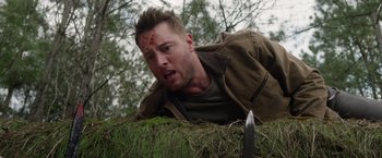 Movie still from “The Hunt” (2020), directed by Craig Zobel – A man with blood on his face is laying on the ground with a knife; Close Up shot, Low angle