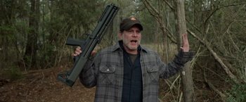Movie still from “The Hunt” (2020), directed by Craig Zobel – A man holding a gun in a wooded area; Medium shot, Low angle