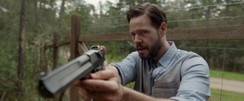 Movie still from “The Hunt” (2020), directed by Craig Zobel – A man holding a gun in his hand; Close Up shot, Over the shoulder angle
