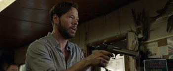 Movie still from “The Hunt” (2020), directed by Craig Zobel – A man holding a gun in his hand; Close Up shot, Low angle