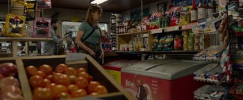 Movie still from “The Hunt” (2020), directed by Craig Zobel – A woman standing in front of an ice cream display; Medium shot, Over the shoulder angle