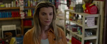 Movie still from “The Hunt” (2020), directed by Craig Zobel – A woman in an orange shirt is looking at the camera; Close Up shot, Over the shoulder angle