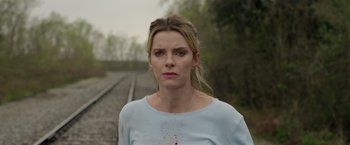 Movie still from “The Hunt” (2020), directed by Craig Zobel – A woman standing in front of a train track; Close Up shot, Over the shoulder angle