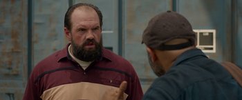 Movie still from “The Hunt” (2020), directed by Craig Zobel – A man with a goatee talking to another man; Close Up shot, Over the shoulder angle