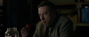 Movie still from “The Hunt” (2020), directed by Craig Zobel – A person wearing a suit and tie; Close Up shot, High angle