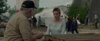 Movie still from “The Hunt” (2020), directed by Craig Zobel – A woman in a white shirt and a man in a brown hat; Medium shot, Over the shoulder angle