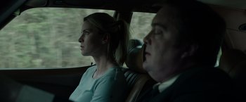 Movie still from “The Hunt” (2020), directed by Craig Zobel – A man and a woman sitting in the back seat of a car; Close Up shot, Low angle