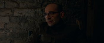 Movie still from “The Hunt” (2020), directed by Craig Zobel – A man with glasses is sitting in the dark; Close Up shot, Over the shoulder angle