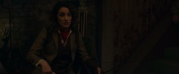 Movie still from “The Hunt” (2020), directed by Craig Zobel – A woman holding a sword in a dark room; Medium shot, Over the shoulder angle