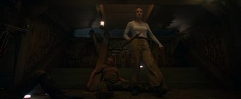 Movie still from “The Hunt” (2020), directed by Craig Zobel – A man and a woman are standing in the dark; Wide shot, Low angle