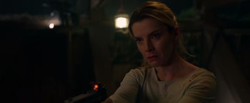 Movie still from “The Hunt” (2020), directed by Craig Zobel – A woman holding a gun in a dark room; Close Up shot, Over the shoulder angle