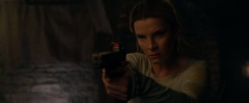 Movie still from “The Hunt” (2020), directed by Craig Zobel – A woman is holding a gun in a dark room; Close Up shot, Low angle