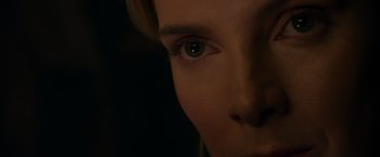 Movie still from “The Hunt” (2020), directed by Craig Zobel – A woman's face with a dark background; Extreme Close Up shot, Over the shoulder angle