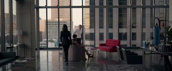 Movie still from “The Hunt” (2020), directed by Craig Zobel – A group of people standing around a living room with couches; Wide shot, Over the shoulder angle