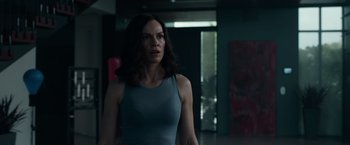 Movie still from “The Hunt” (2020), directed by Craig Zobel – A woman standing in a dark room looking at the camera; Medium shot, Low angle