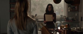 Movie still from “The Hunt” (2020), directed by Craig Zobel – A woman standing in front of a mirror holding a piece of paper; Medium shot, Over the shoulder angle