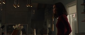 Movie still from “The Hunt” (2020), directed by Craig Zobel – A woman standing next to a vase in a room; Medium shot, Over the shoulder angle