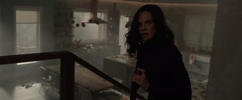Movie still from “The Hunt” (2020), directed by Craig Zobel – A woman standing in a kitchen holding onto a railing; Medium shot, Low angle