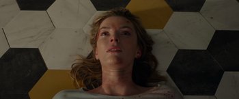 Movie still from “The Hunt” (2020), directed by Craig Zobel – A woman with a scar on her face laying on the ground; Close Up shot, Overhead angle