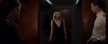 Movie still from “The Hunt” (2020), directed by Craig Zobel – A woman in a black dress holding a gun in a dark room; Medium shot, Low angle