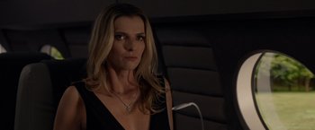 Movie still from “The Hunt” (2020), directed by Craig Zobel – A woman with long blonde hair wearing a black dress; Close Up shot, Over the shoulder angle