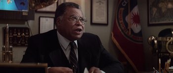 Movie still from “The Hunt for Red October” (1990), directed by John McTiernan – An older man in a suit and tie; Close Up shot, Over the shoulder angle