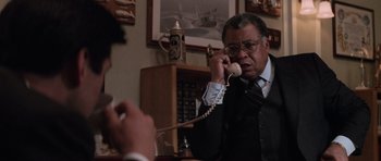 Movie still from “The Hunt for Red October” (1990), directed by John McTiernan – An older man talking on a phone while another man watches; Close Up shot, Over the shoulder angle