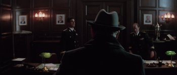 Movie still from “The Hunt for Red October” (1990), directed by John McTiernan – A man wearing a hat in a room with a man in a suit; Medium shot, Over the shoulder angle