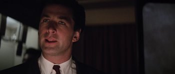 Movie still from “The Hunt for Red October” (1990), directed by John McTiernan – A person wearing a suit and tie; Close Up shot, Low angle