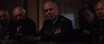 Movie still from “The Hunt for Red October” (1990), directed by John McTiernan – An older man in a military uniform sitting at a table; Close Up shot, Low angle