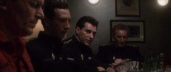 Movie still from “The Hunt for Red October” (1990), directed by John McTiernan – A group of men in military uniforms sitting next to each other in a room; Close Up shot, High angle