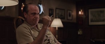 Movie still from “The Hunt for Red October” (1990), directed by John McTiernan – A man sitting in a chair with a cigarette in his mouth; Close Up shot, Low angle