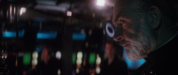 Movie still from “The Hunt for Red October” (1990), directed by John McTiernan – A man with a beard and glasses on; Close Up shot, Over the shoulder angle