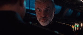 Movie still from “The Hunt for Red October” (1990), directed by John McTiernan – An older man with grey hair looking at the camera; Close Up shot, Over the shoulder angle