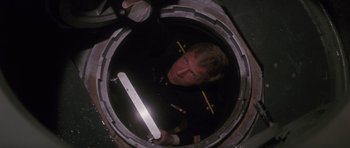 Movie still from “The Hunt for Red October” (1990), directed by John McTiernan – A man in uniform is looking down into a hole; Medium shot, Overhead angle