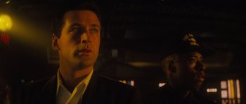 Movie still from “The Hunt for Red October” (1990), directed by John McTiernan – A man standing next to another man wearing a suit; Close Up shot, Low angle