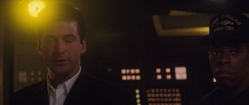 Movie still from “The Hunt for Red October” (1990), directed by John McTiernan – A man wearing a suit and tie standing in front of a computer screen; Close Up shot, Low angle