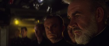 Movie still from “The Hunt for Red October” (1990), directed by John McTiernan – A group of men standing next to each other in a room; Close Up shot, Over the shoulder angle