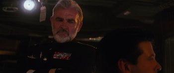 Movie still from “The Hunt for Red October” (1990), directed by John McTiernan – An older man in a military uniform looking at the camera; Close Up shot, Over the shoulder angle