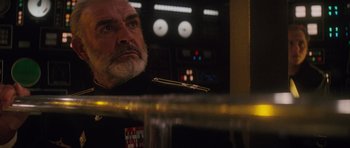 Movie still from “The Hunt for Red October” (1990), directed by John McTiernan – An older man with a beard looking at the camera; Close Up shot, Over the shoulder angle