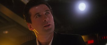 Movie still from “The Hunt for Red October” (1990), directed by John McTiernan – A person wearing a suit and ear buds; Close Up shot, Low angle