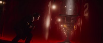 Movie still from “The Hunt for Red October” (1990), directed by John McTiernan – A man holding a gun while standing in a dark room; Wide shot, Low angle