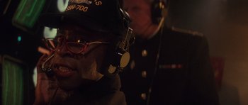 Movie still from “The Hunt for Red October” (1990), directed by John McTiernan – A man wearing a hat and glasses with headphones on; Close Up shot, Over the shoulder angle